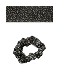 Black scrunchie on a white floral patterned.